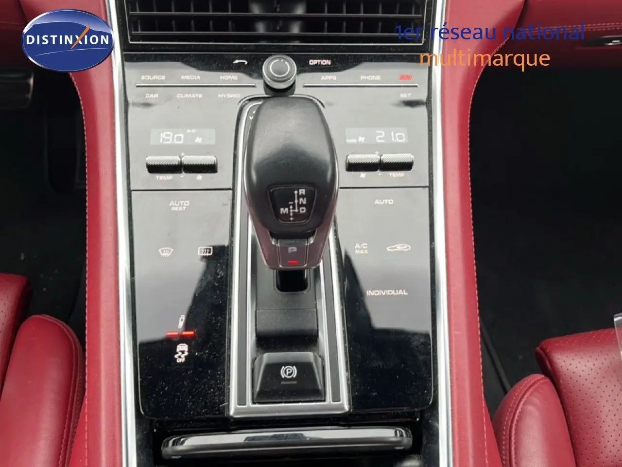 Vue rapprochée de la console centrale noire et levier de vitesse d’une Porsche Panamera 4 E-Hybrid avec sellerie cuir rouge.