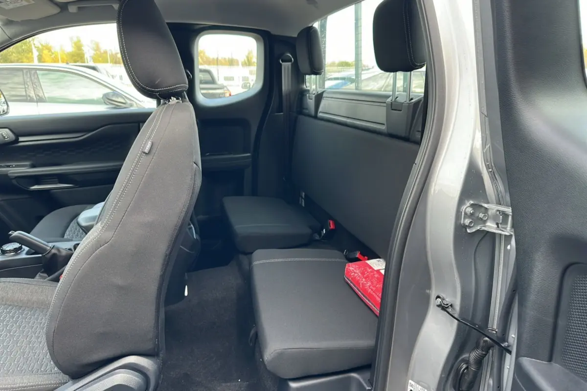 Vue intérieure côté droit du Ford Ranger gris iconic 2026, montrant la banquette arrière compacte et le siège avant en tissu noir.