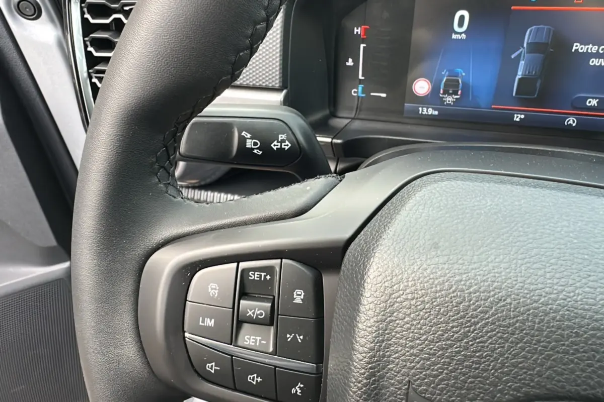 Gros plan sur le volant cuir multifonctions du Ford Ranger gris iconic avec écran digital et commandes au volant visibles.