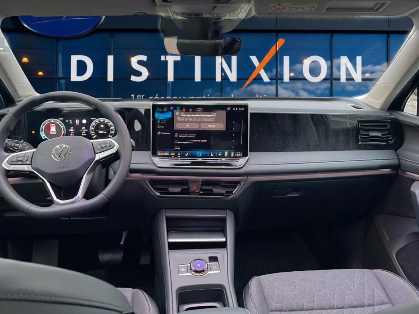 Vue intérieure avant du Volkswagen Tiguan 2025, tableau de bord noir avec écran tactile central et volant multifonction.