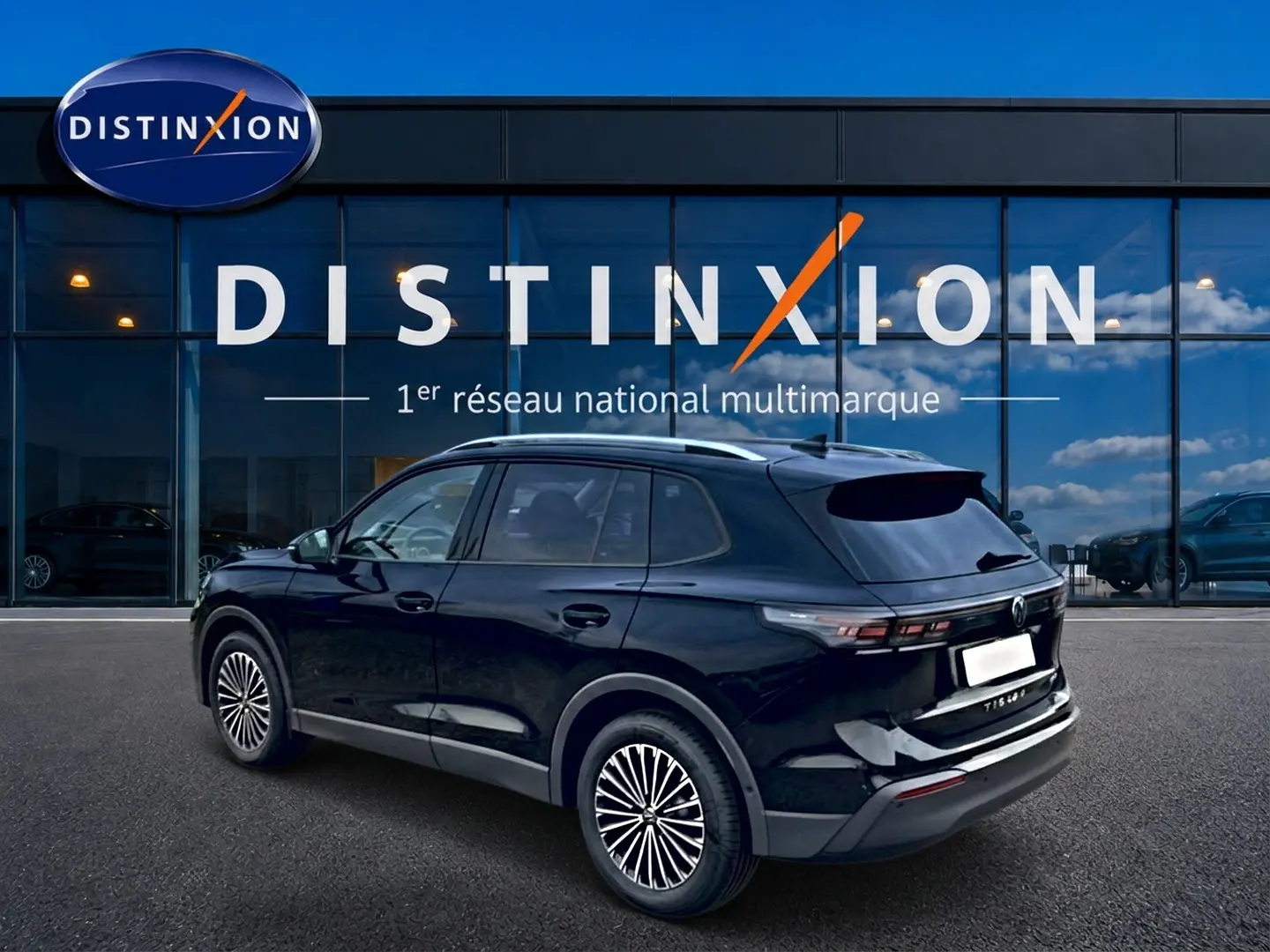 Volkswagen Tiguan noir 2025 en 3/4 arrière droit, avec barres de toit argentées et jantes stylisées.