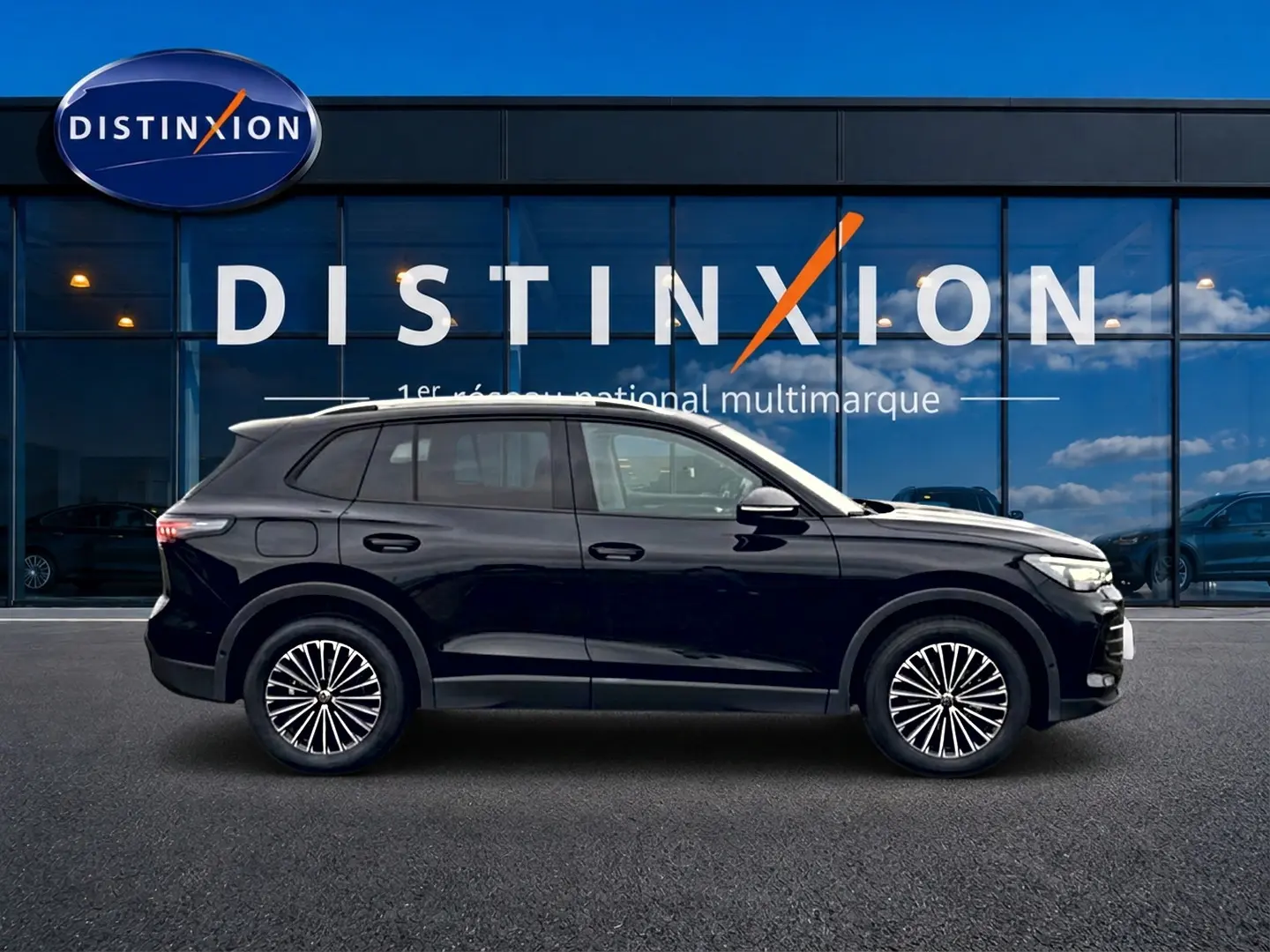 Volkswagen Tiguan 2025 noir en profil droit, avec jantes stylisées et toit ouvrant panoramique visible.