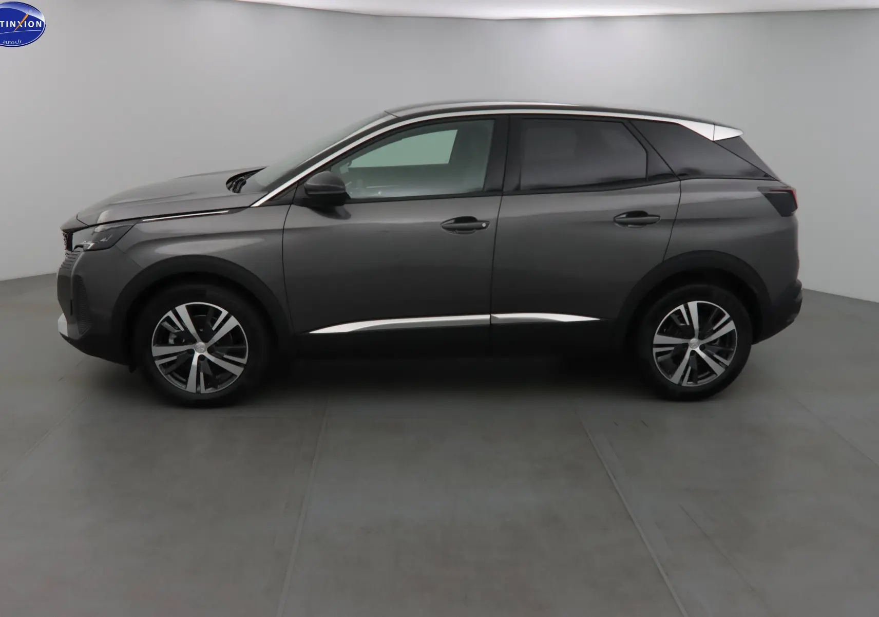 Profil côté gauche du Peugeot 3008 gris platinium métal 2023 avec jantes alliage bicolores et toit noir contrasté.