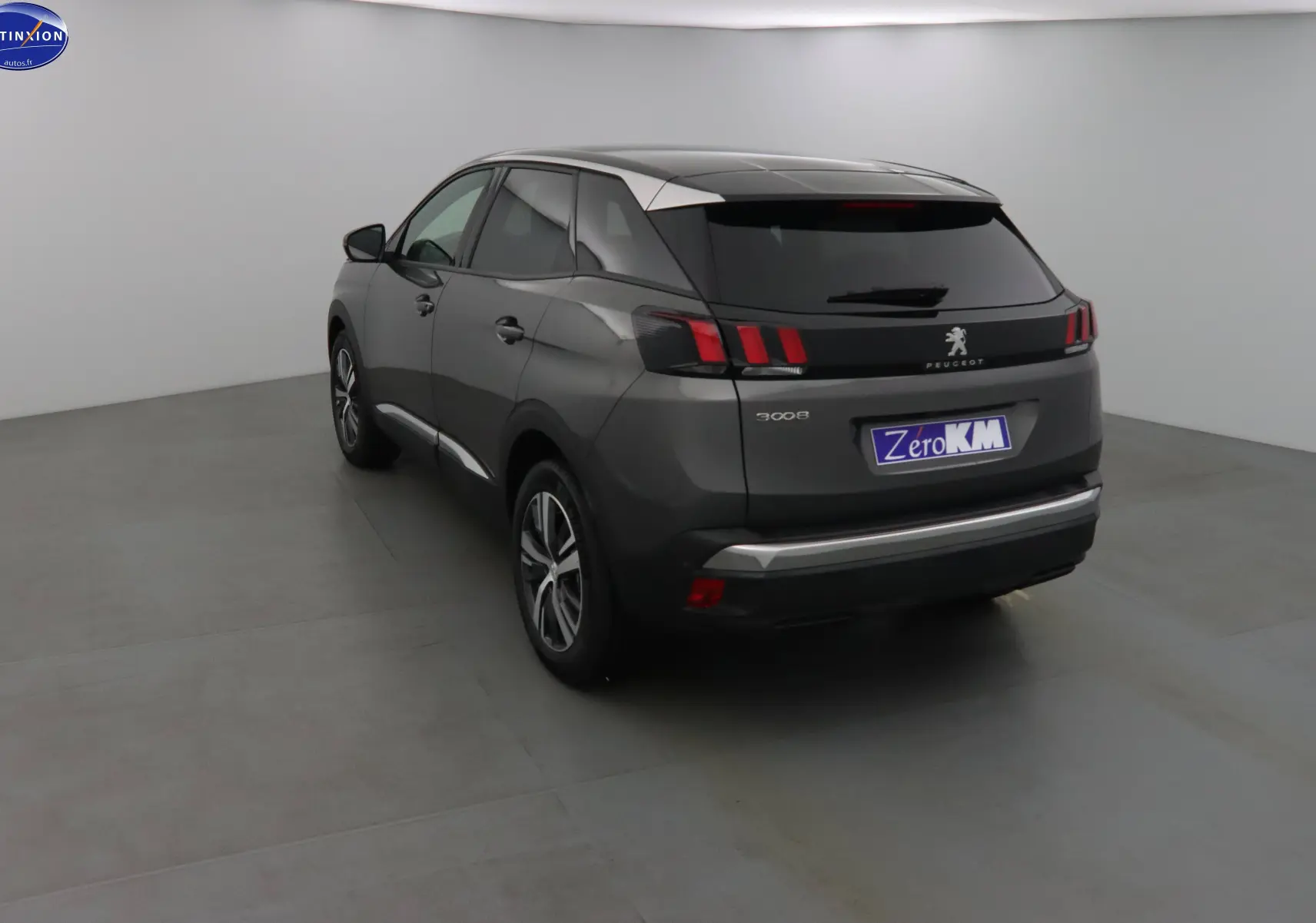 Vue 3/4 arrière droit du Peugeot 3008 gris platinium métal avec feux arrière à griffes et jantes alliage bicolores.