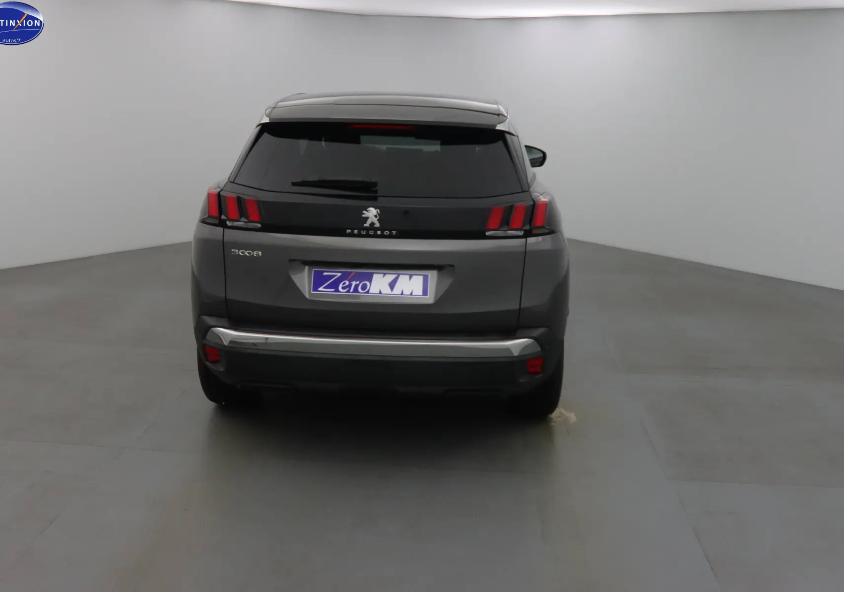 Vue arrière d'un Peugeot 3008 gris platinium métal 2023 avec feux LED et hayon fermé dans un studio.