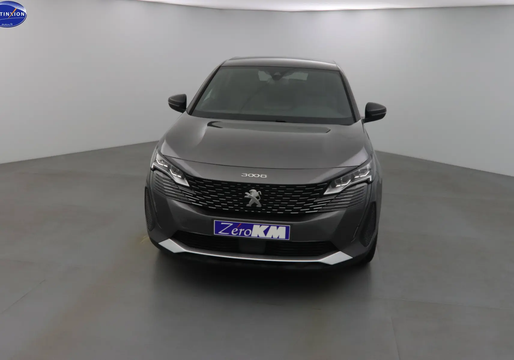 Vue de face d'un Peugeot 3008 gris platinium métal 2023 avec calandre noire et phares LED distinctifs.