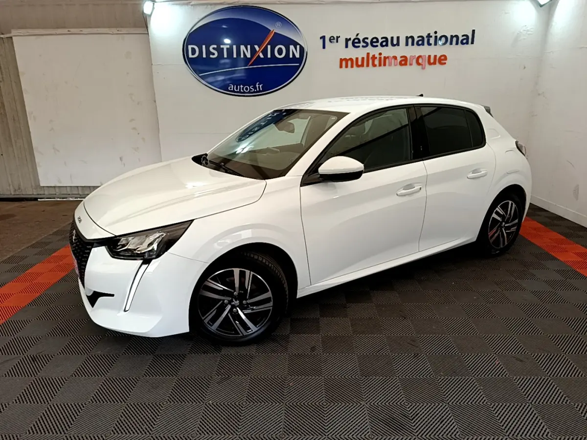Peugeot 208 blanc vue 3/4 avant droit, avec jantes alliage et vitres teintées en intérieur showroom