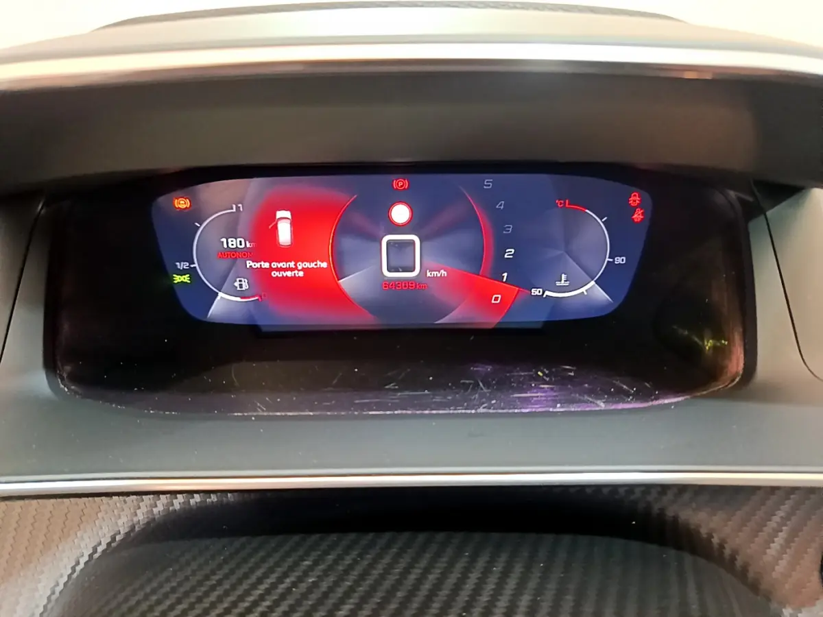 Affichage numérique du tableau de bord de la Peugeot 208 blanc, montrant une porte avant gauche ouverte et 64 309 km au compteur.