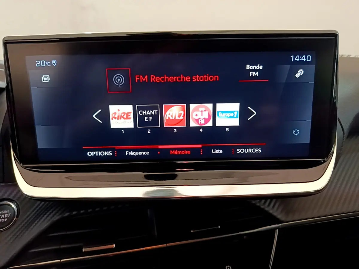 Écran tactile central du tableau de bord du Peugeot 208 blanc, affichant la recherche de station FM à 14h40.