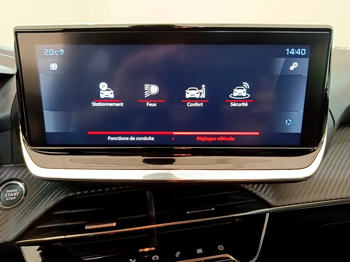 Écran tactile central affichant les réglages véhicule dans l'habitacle d'une Peugeot 208 blanche, vue de face rapprochée.