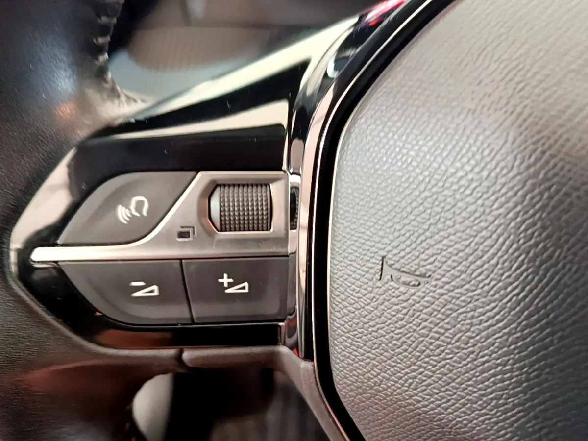 Gros plan sur les commandes du volant cuir noir de la Peugeot 208 PureTech 100 S&S Allure Business 2020.