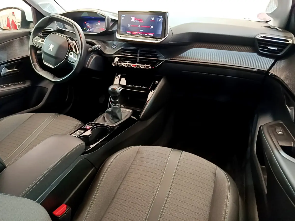 Intérieur avant de la Peugeot 208 PureTech blanc, vue côté conducteur avec tableau de bord et écran tactile central.