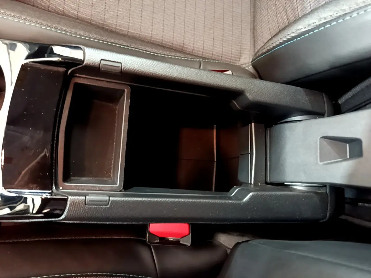 Vue plongeante sur le rangement central noir entre les sièges avant du Peugeot 208 blanc PureTech 100 S&S Allure Business 2020.