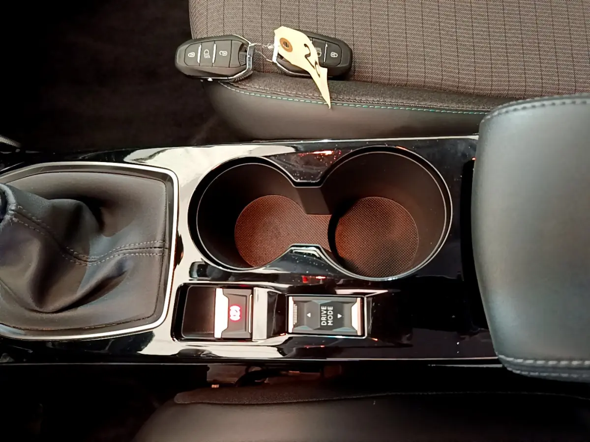 Vue rapprochée de la console centrale noire avec levier de vitesse manuel et porte-gobelets dans une Peugeot 208 blanche 2020.