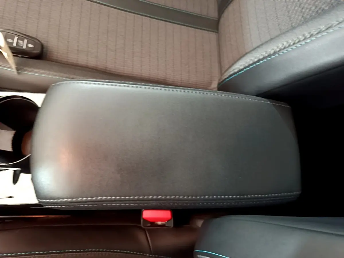 Accoudoir central noir et siège tissu gris avec surpiqûres bleues dans Peugeot 208 PureTech 100 S&S Allure Business 2020