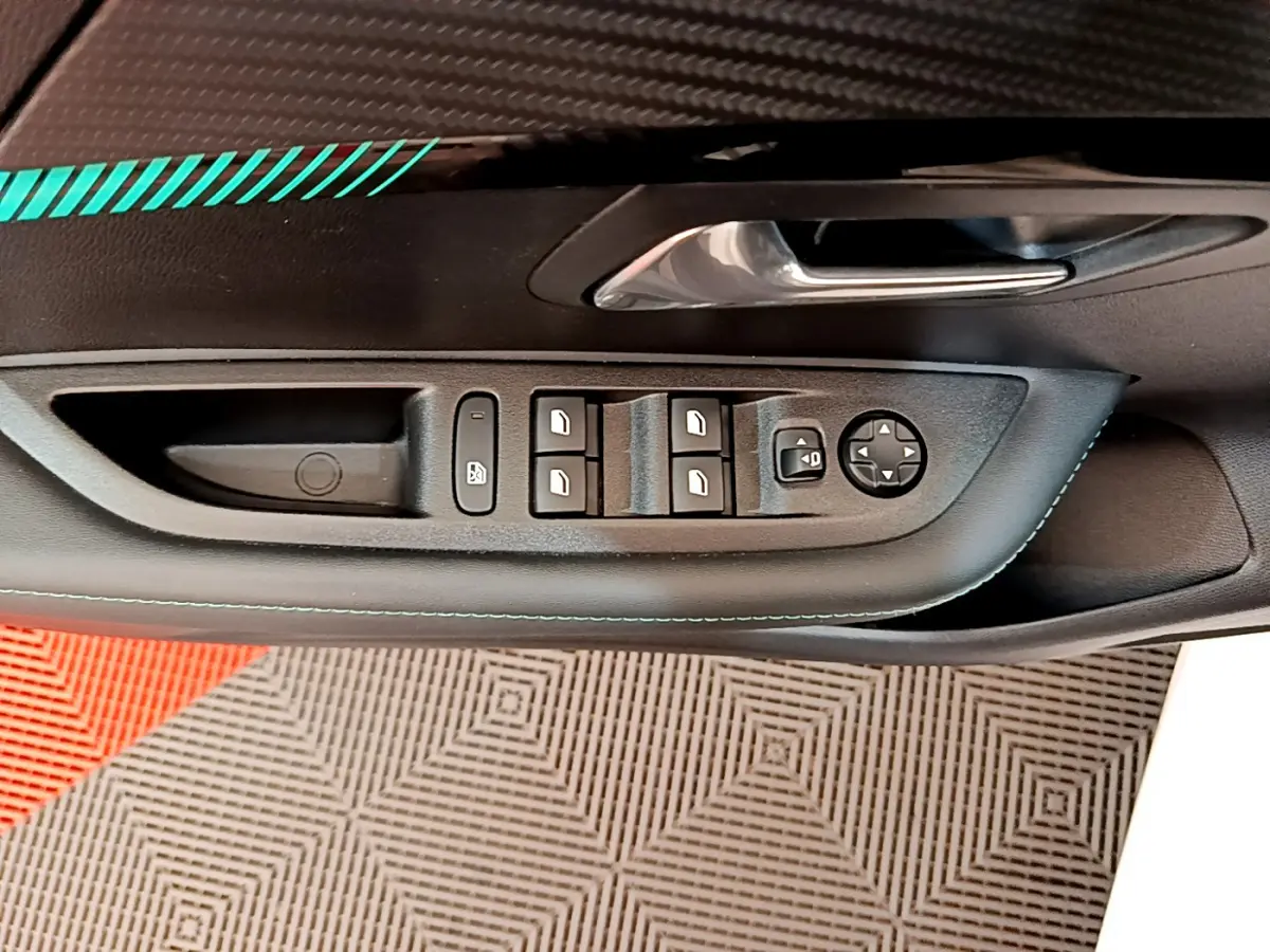 Gros plan sur la commande des vitres et rétroviseurs côté conducteur d'une Peugeot 208 blanche, intérieur noir.
