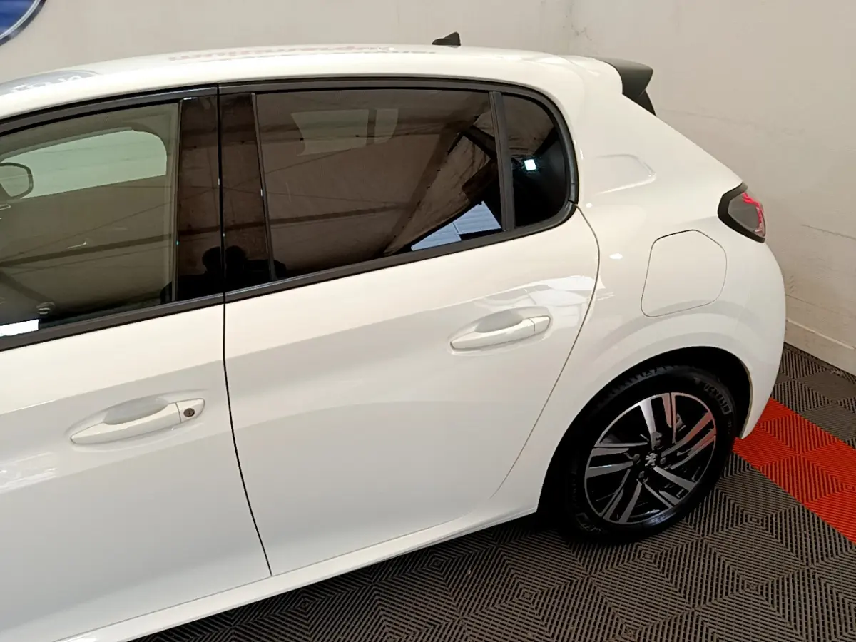 Vue latérale droite du Peugeot 208 blanc 2020, soulignant la porte arrière et la jante alliage moderne.