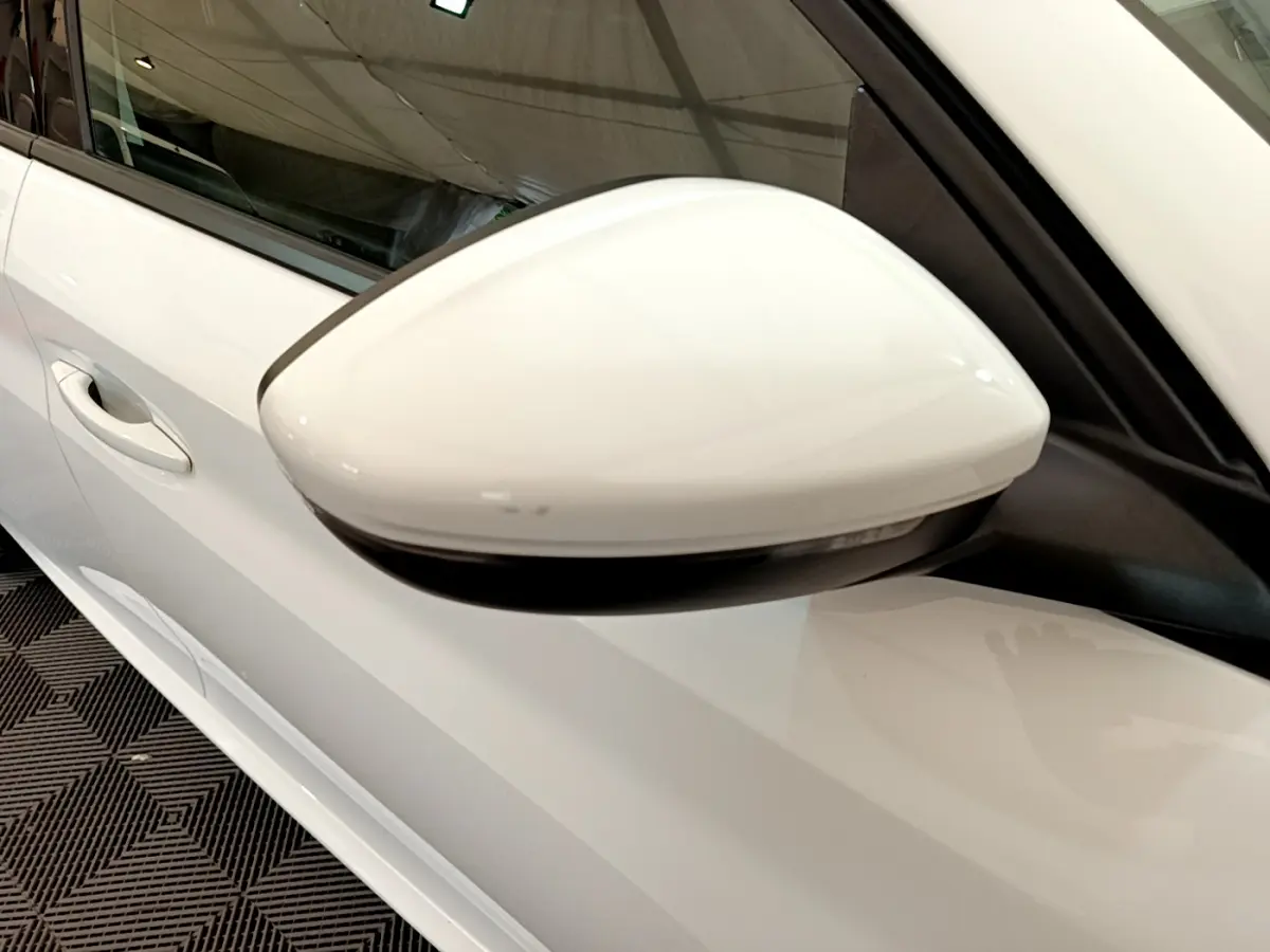 Gros plan sur le rétroviseur côté gauche blanc d'une Peugeot 208 PureTech 100 S&S Allure Business 2020.