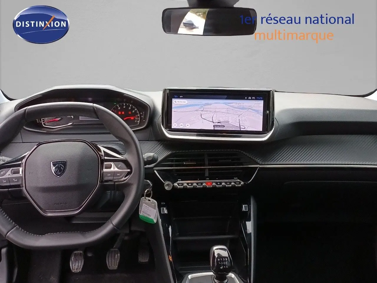 Vue intérieure du tableau de bord et volant de la Peugeot 208 gris Artense, avec écran tactile et boîte manuelle.