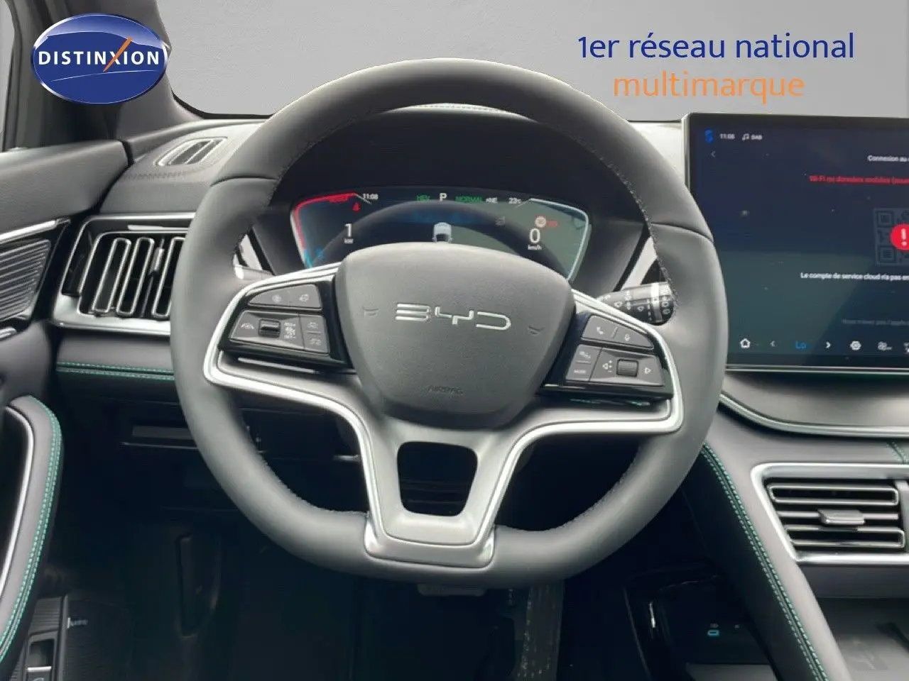 Vue intérieure centrée sur le volant BYD SEAL U gris avec tableau de bord numérique et écran tactile moderne.