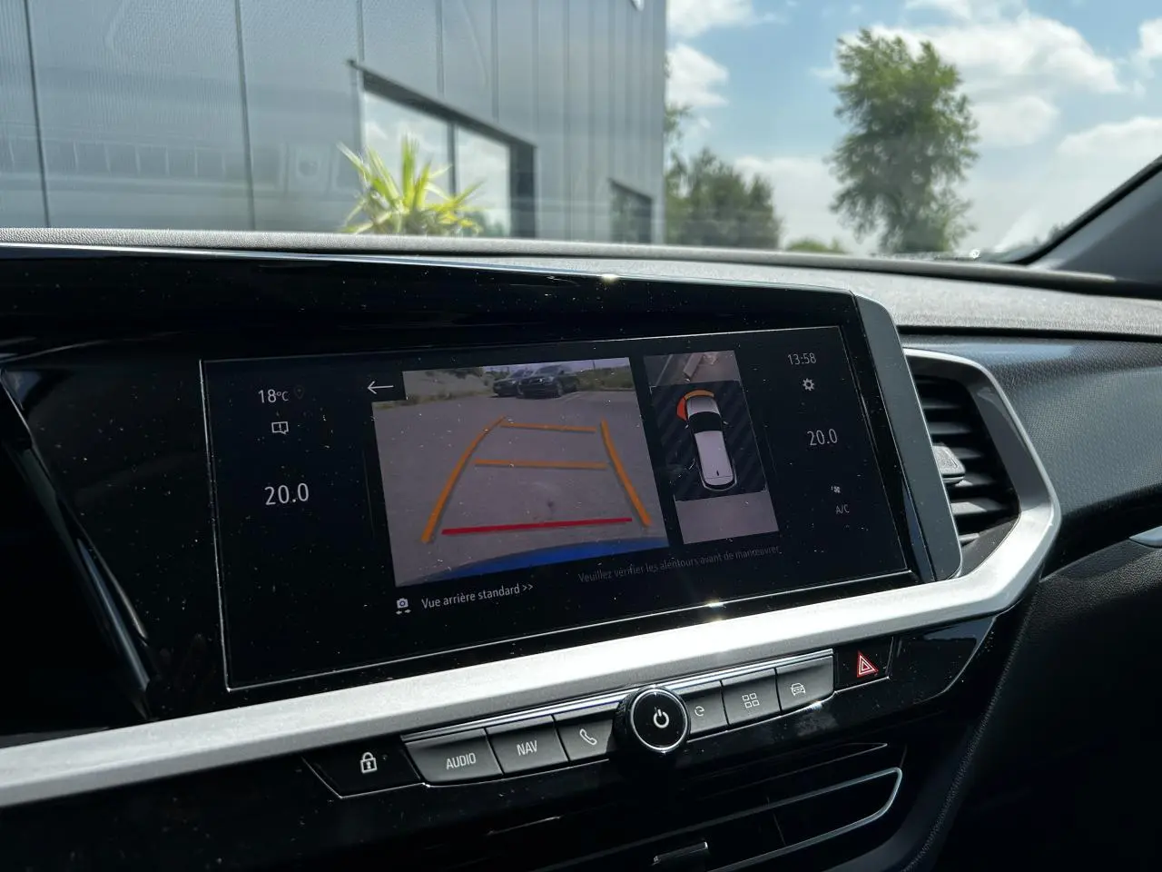 Écran tactile central de l'Opel Grandland bleu Vertigo montrant la caméra de recul et la vision 360° intérieure.