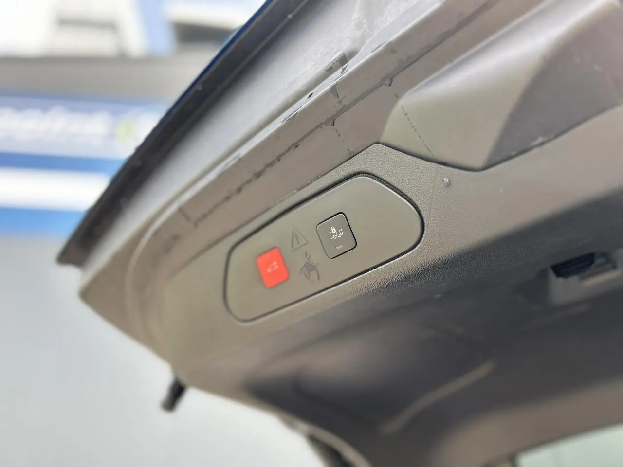 Boutons de commande du hayon électrique sur la face intérieure du coffre d'un Opel Grandland Bleu Vertigo.