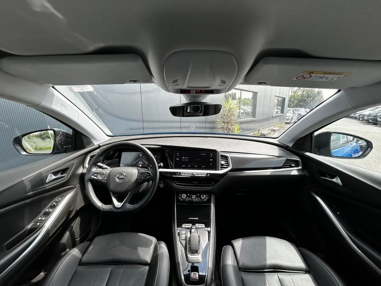 Intérieur avant de l'Opel Grandland 1.6 Hybrid 225 Ultimate, tableau de bord moderne et volant cuir multifonction.