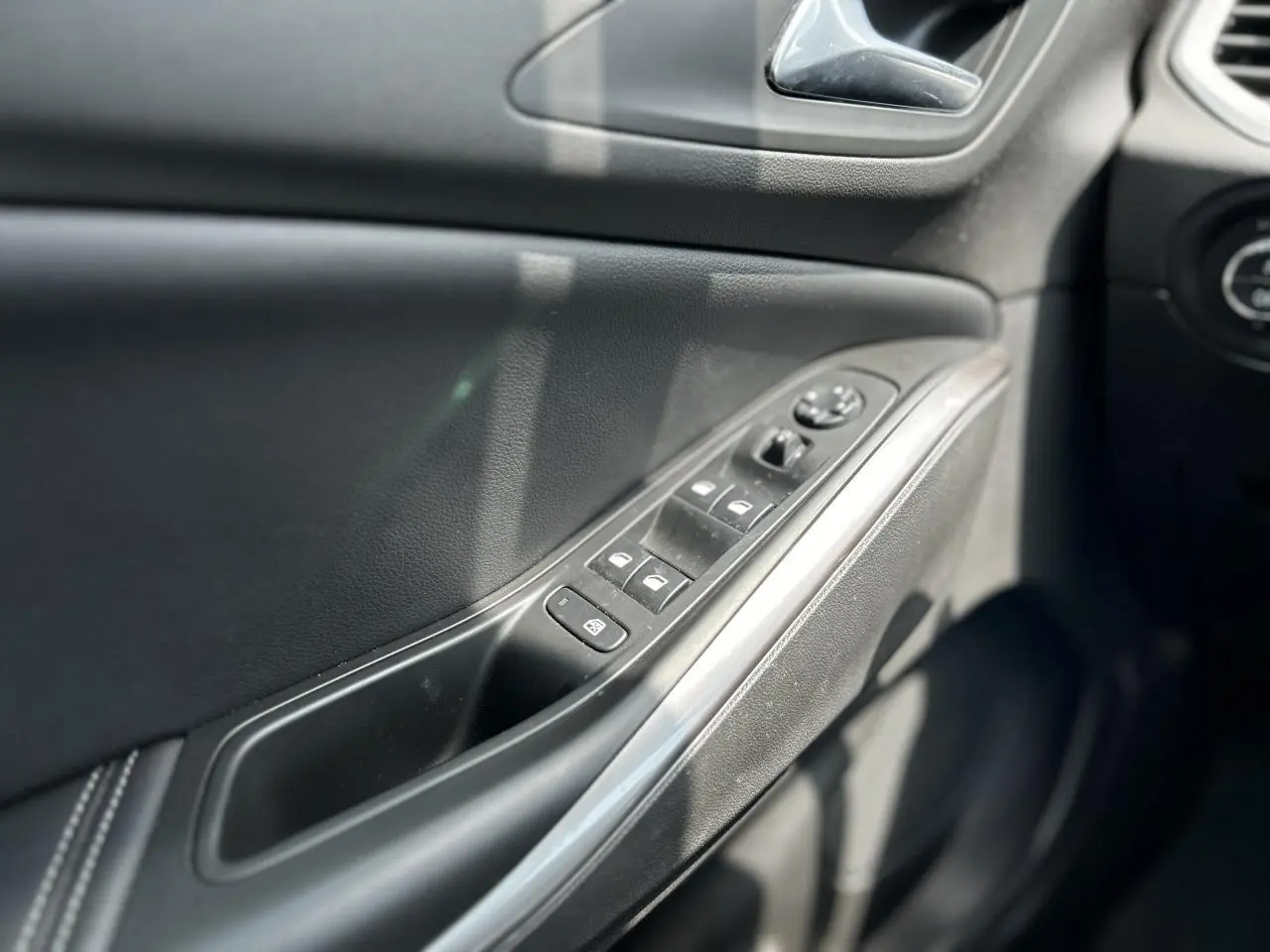 Détail de la porte côté conducteur de l'Opel Grandland 1.6 Hybrid 225 Ultimate avec commandes de vitres et rétroviseurs électriques.