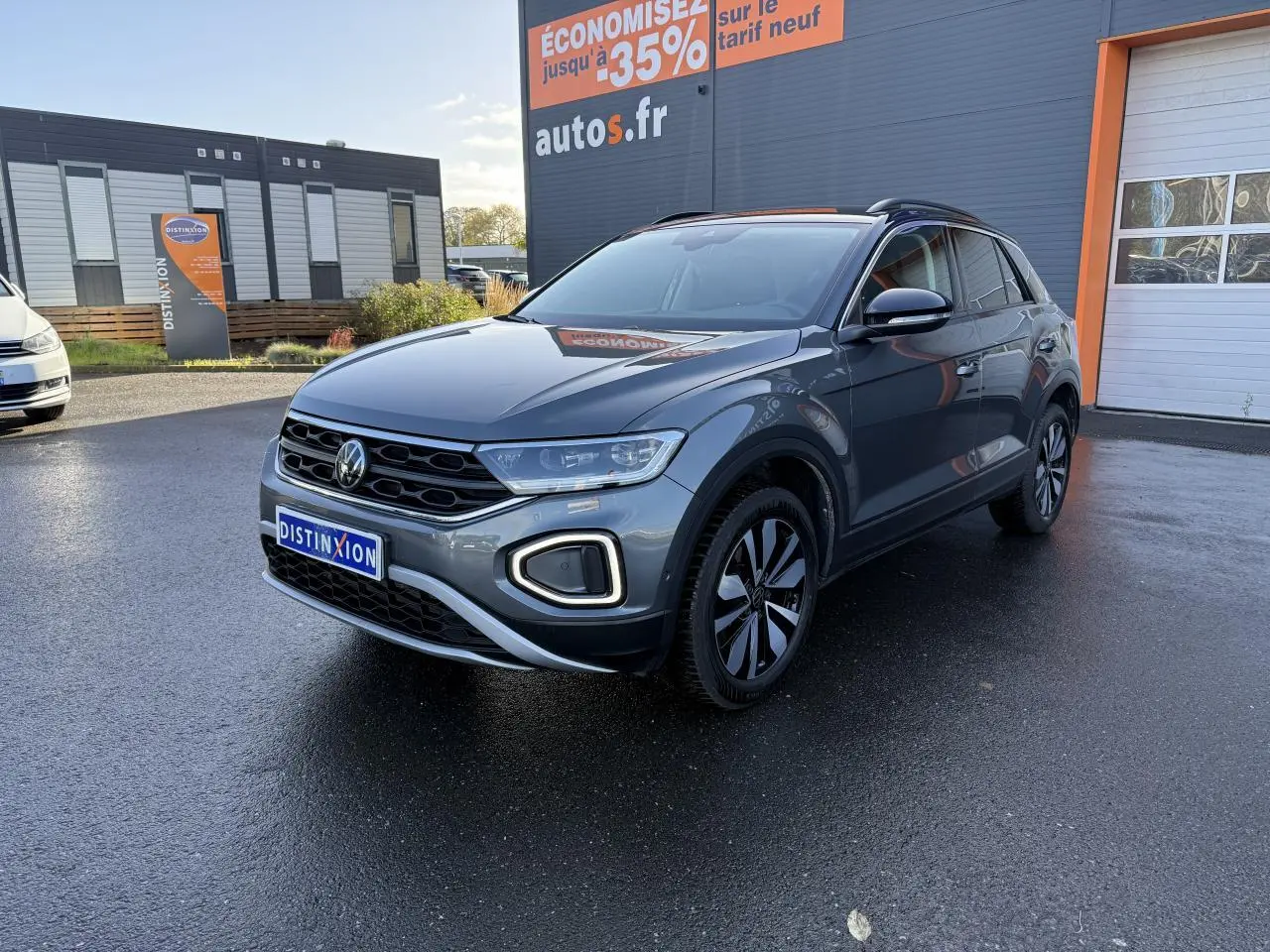 Volkswagen T-Roc gris Indium métallisé en 3/4 avant droit, avec toit noir et jantes distinctives.