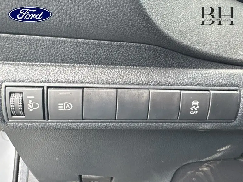 Panneau de commandes intérieures noires avec boutons de réglage des phares et de l'ESP sur Toyota Corolla gris Manhattan.