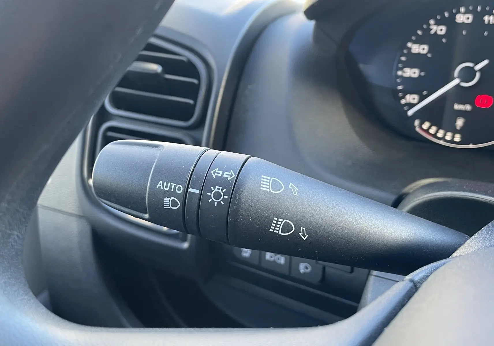 Gros plan sur la commande des phares et clignotants à gauche du volant dans un Peugeot Boxer Fourgon blanc 2025.