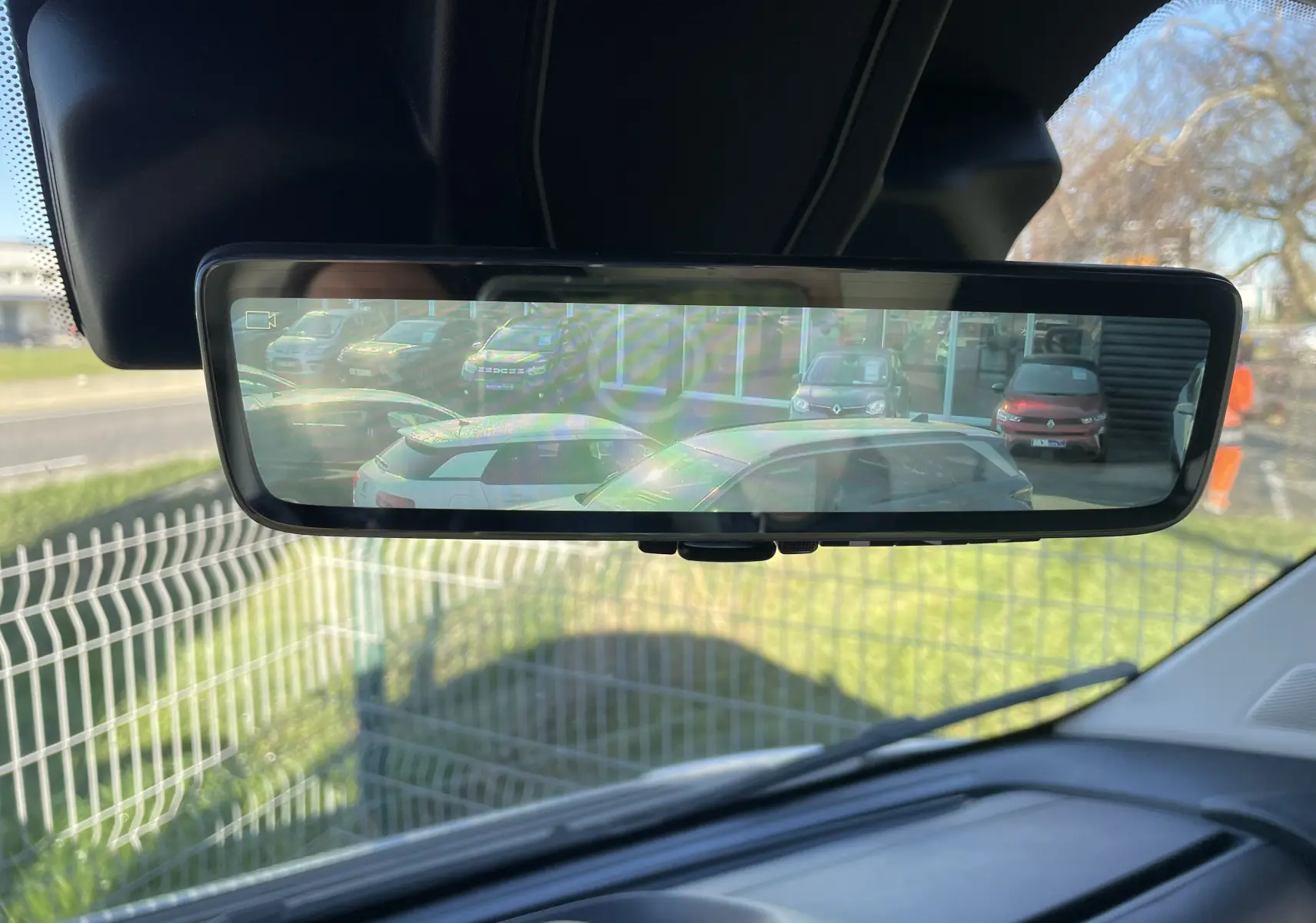 Rétroviseur intérieur affichant une vue arrière avec plusieurs véhicules stationnés, prise depuis un Peugeot Boxer Fourgon blanc.