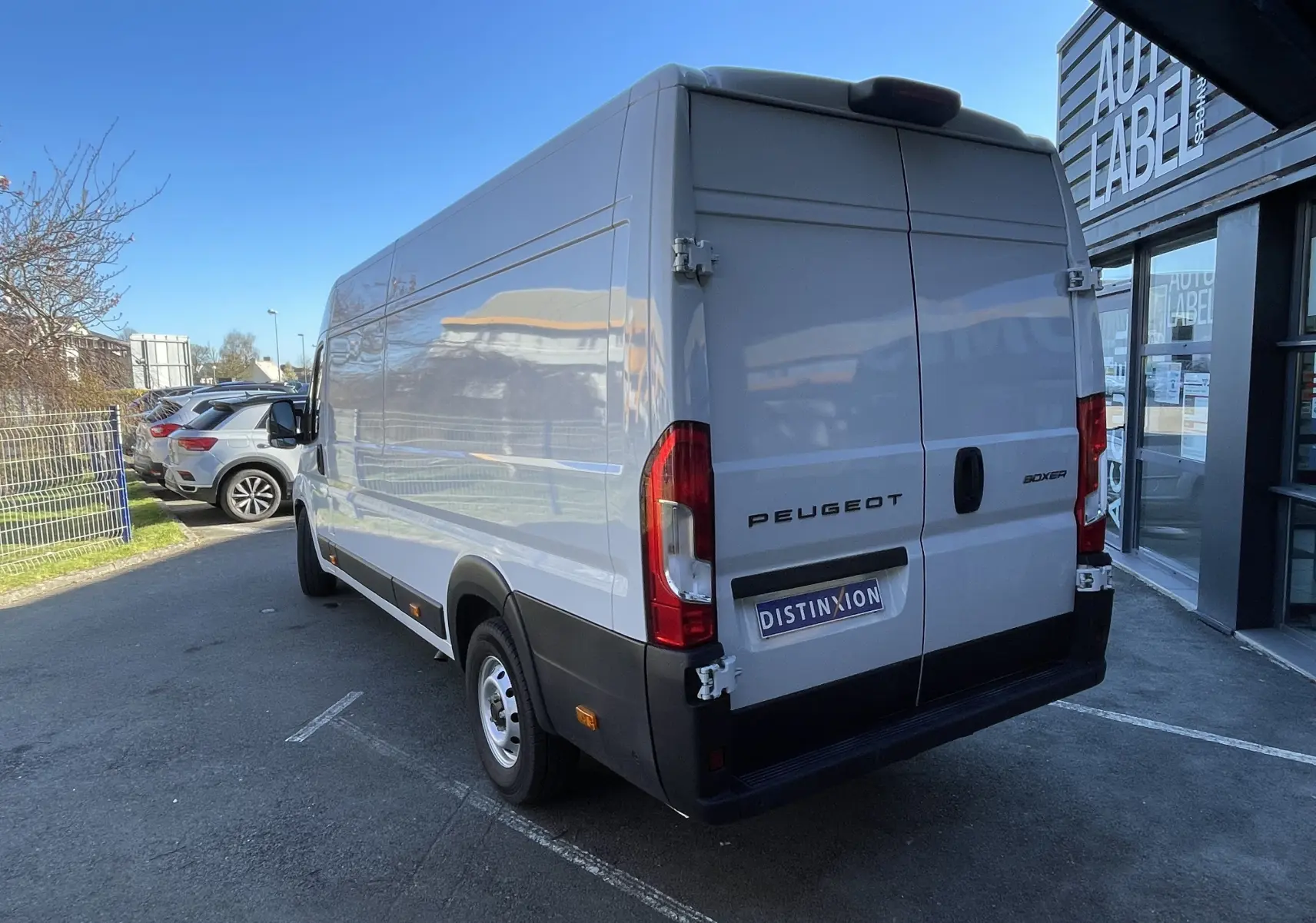 Vue 3/4 arrière droite d’un Peugeot Boxer Fourgon blanc 2025 avec portes arrière battantes et jantes acier 16 pouces.