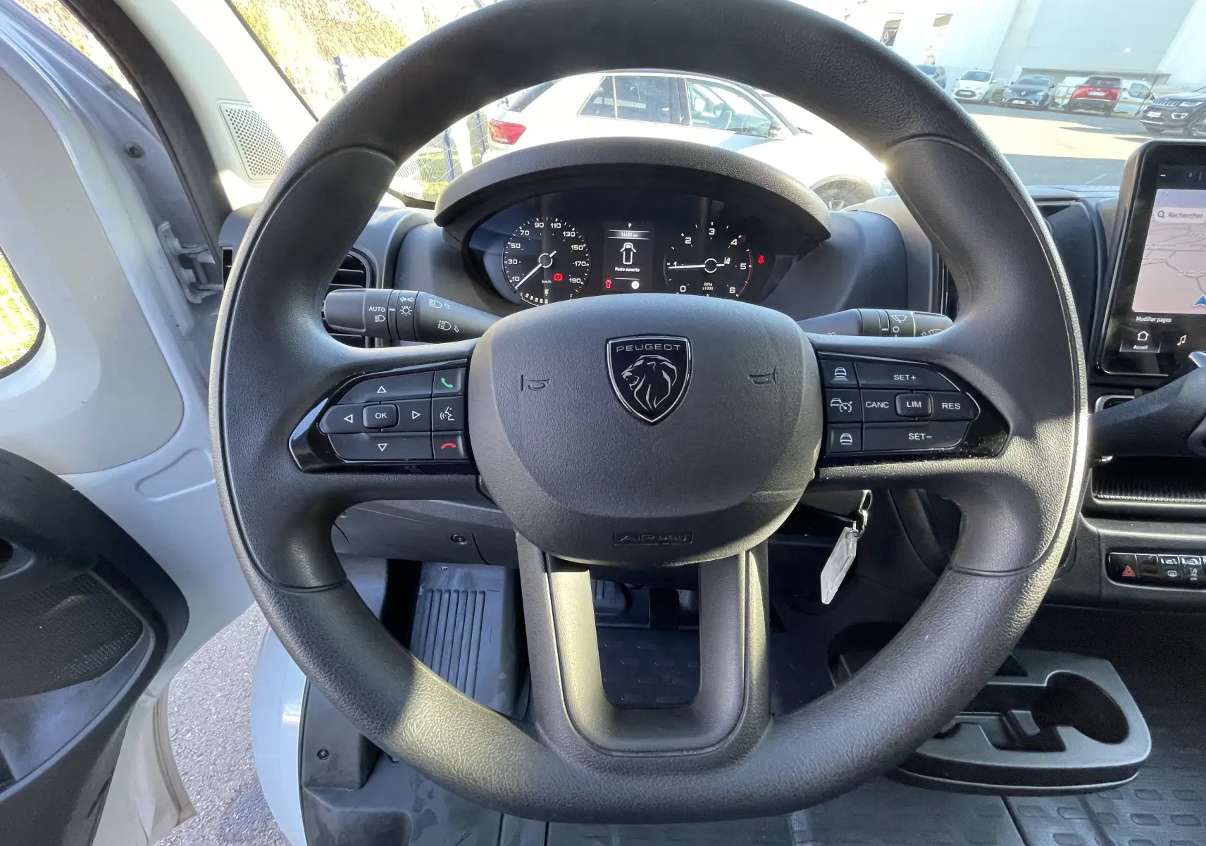 Vue centrée sur le volant du Peugeot Boxer Fourgon blanc 2025, avec tableau de bord et écran tactile visibles.