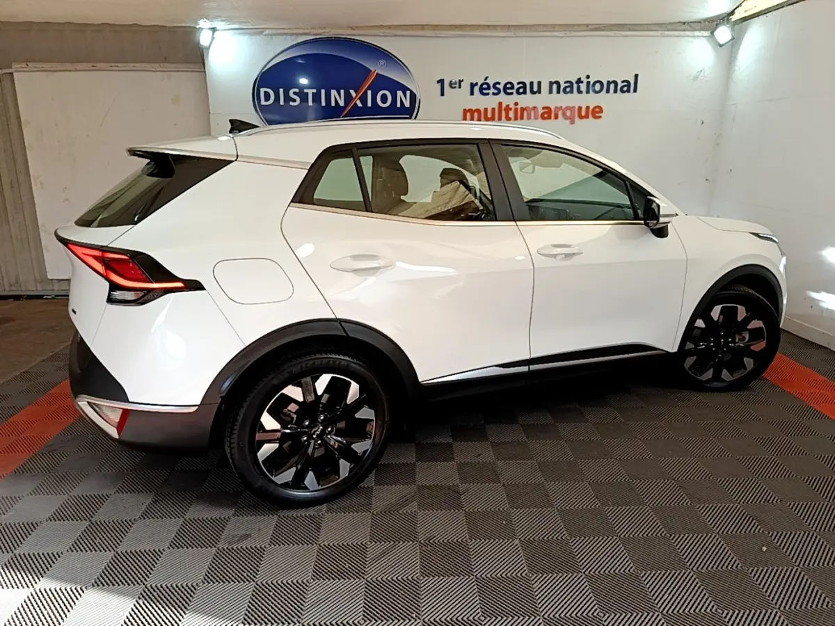 KIA Sportage blanc vue de profil côté gauche, jantes noires, feux arrière LED et toit avec spoiler.