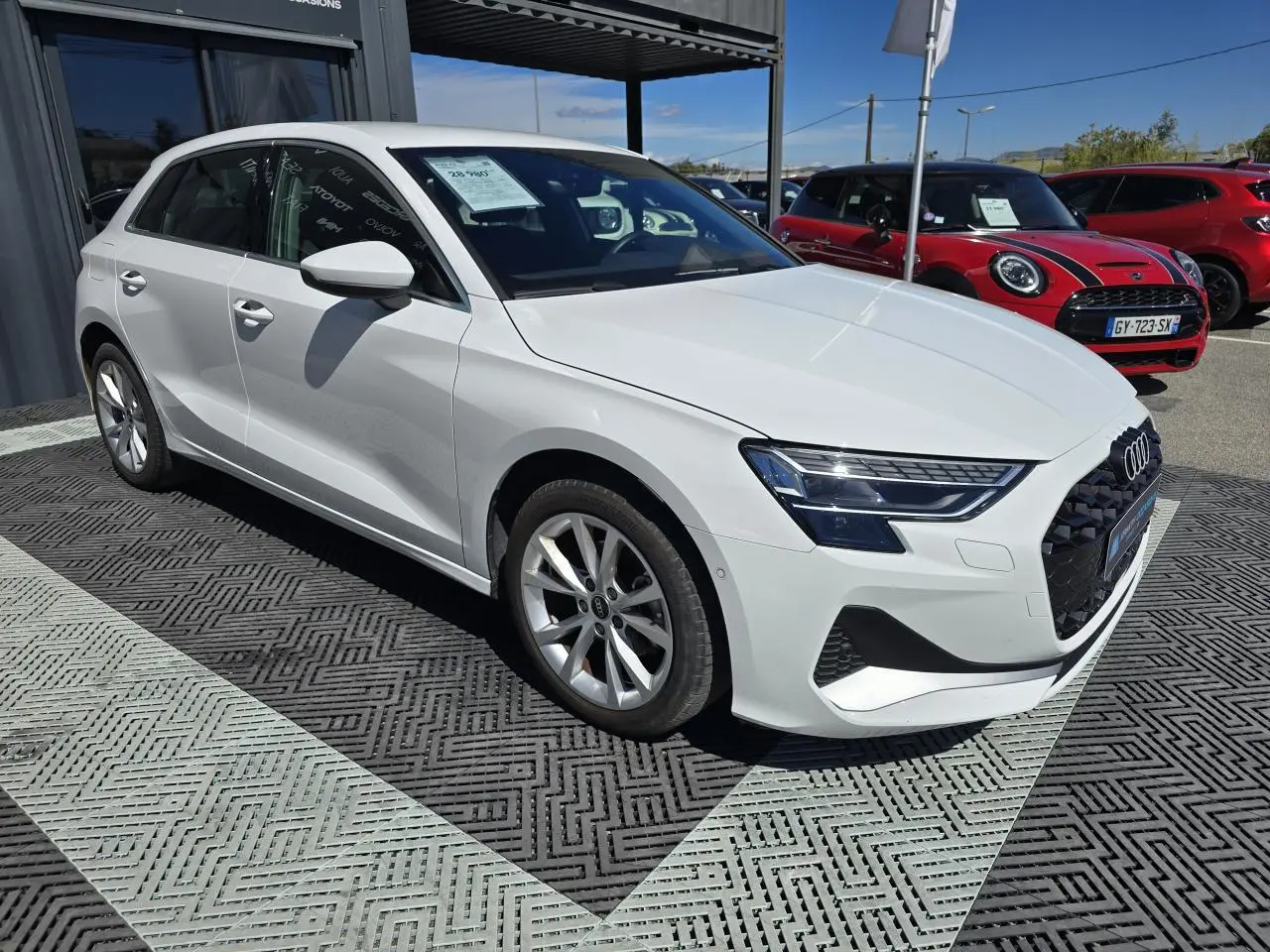Audi A3 Sportback blanc Arkona vue 3/4 avant droit avec phares LED et jantes alliage 5 branches parallèles.