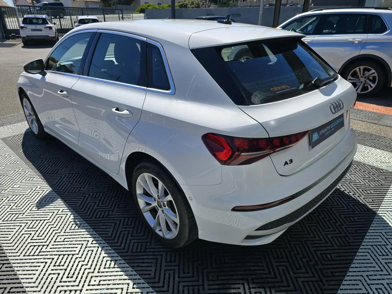 Audi A3 Sportback blanc Arkona vue 3/4 arrière droit, avec feux arrière LED et jantes alliage 5 branches.