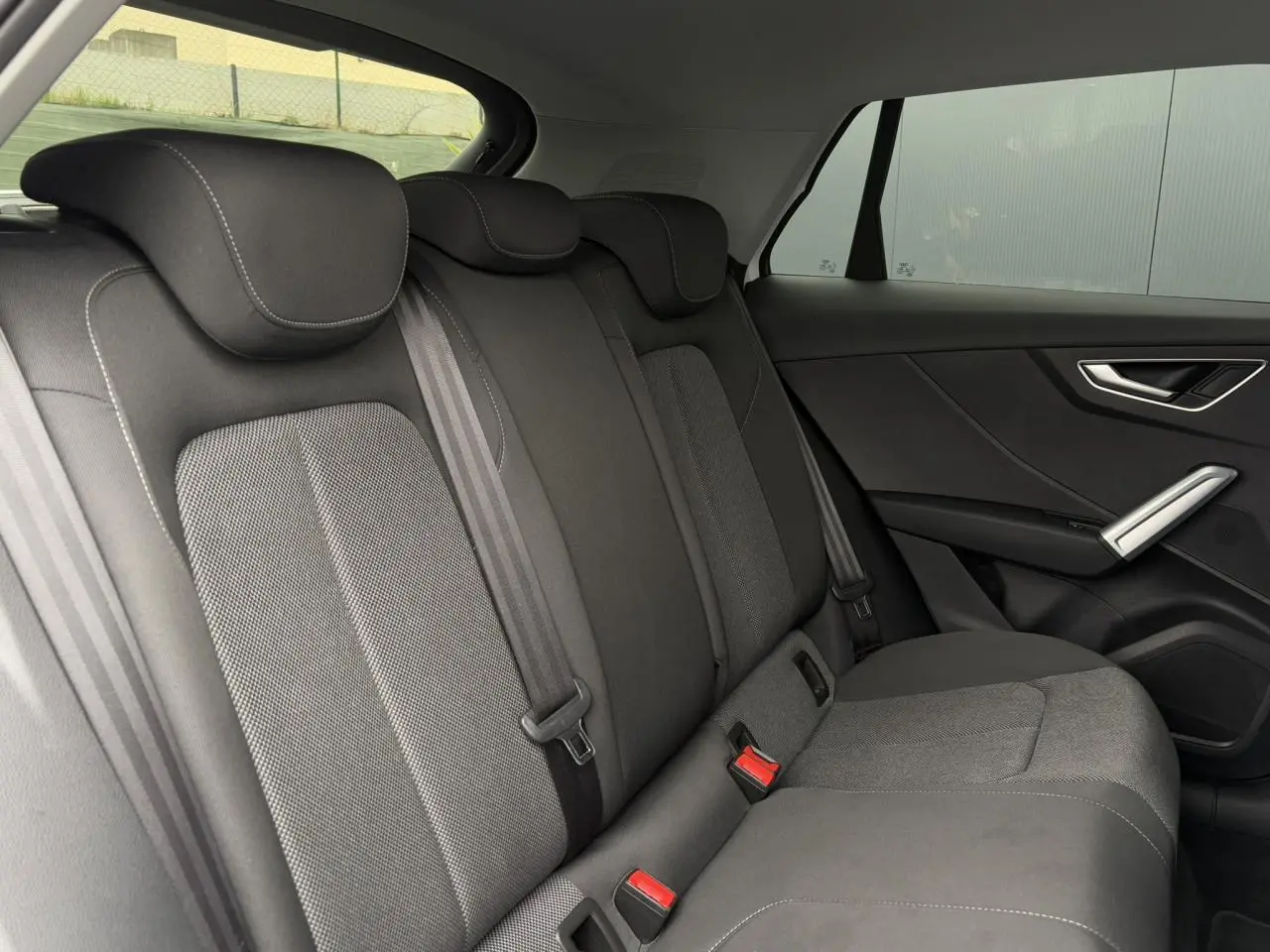 Vue latérale droite des sièges arrière en tissu gris foncé de l'Audi Q2 30 TFSI 110 S-Line 2024.