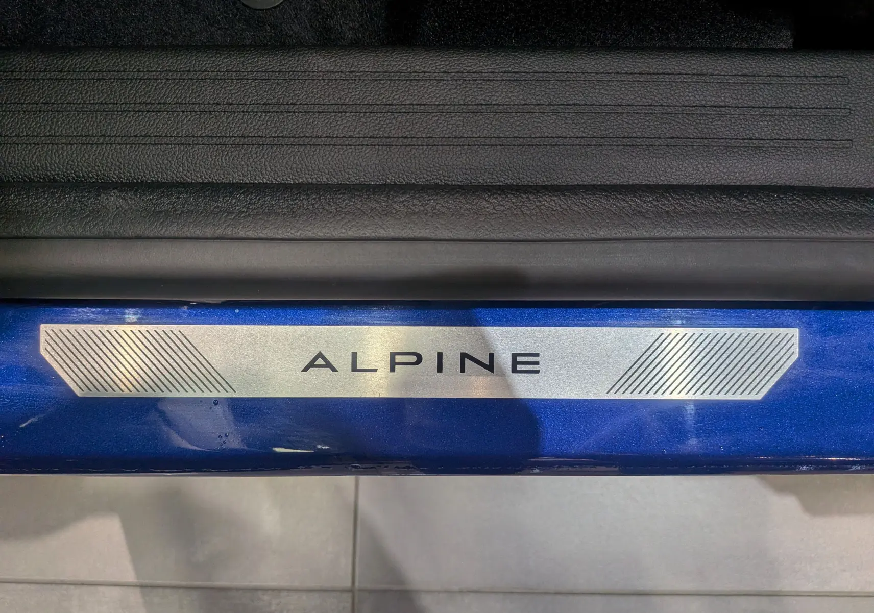Plaque de seuil de porte bleue Iron avec inscription Alpine sur Renault Captur E-TECH Full Hybrid 2025, vue intérieure côté gauche.