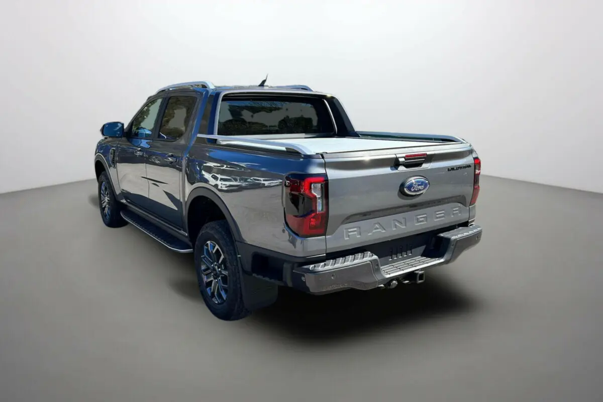 Ford Ranger 2026 gris carbone, vue 3/4 arrière droit, avec benne couverte et jantes alu 18 pouces.
