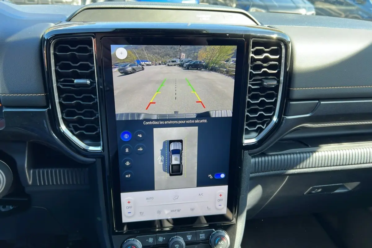 Vue intérieure du tableau de bord du Ford Ranger gris carbone 2026, avec écran tactile central affichant caméra 360° et aide au stationnement.