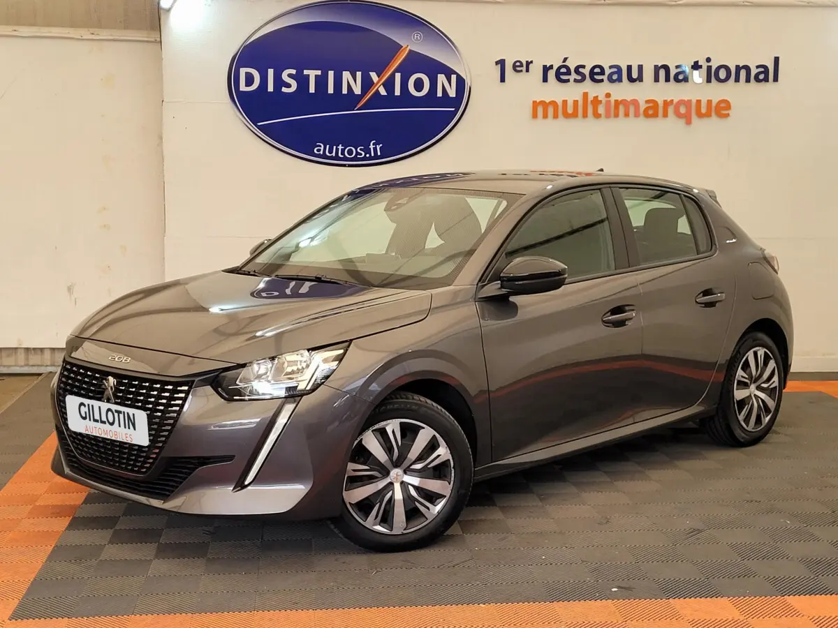 Peugeot 208 gris foncé vue 3/4 avant droit, avec calandre distinctive et jantes modernes en concession.