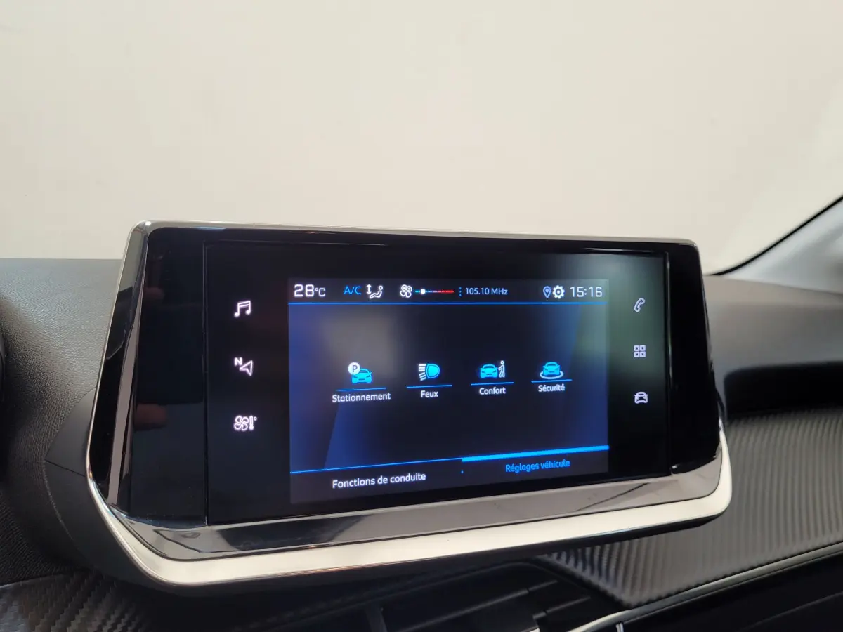 Écran tactile central 7 pouces de la Peugeot 208 gris foncé, affichant les réglages de conduite et sécurité.