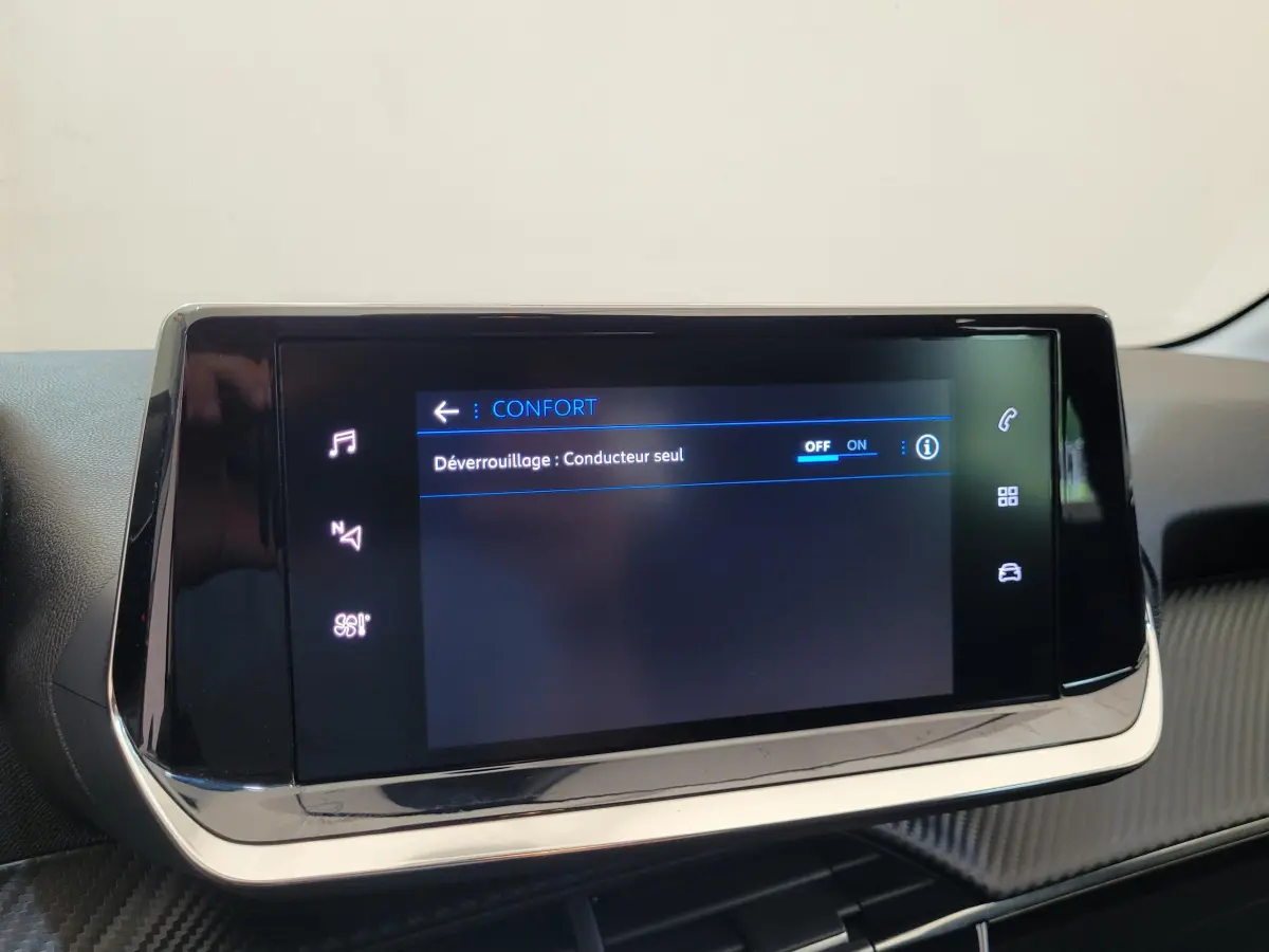 Écran tactile central de la Peugeot 208 gris foncé affichant le menu confort avec option déverrouillage conducteur seul activée.