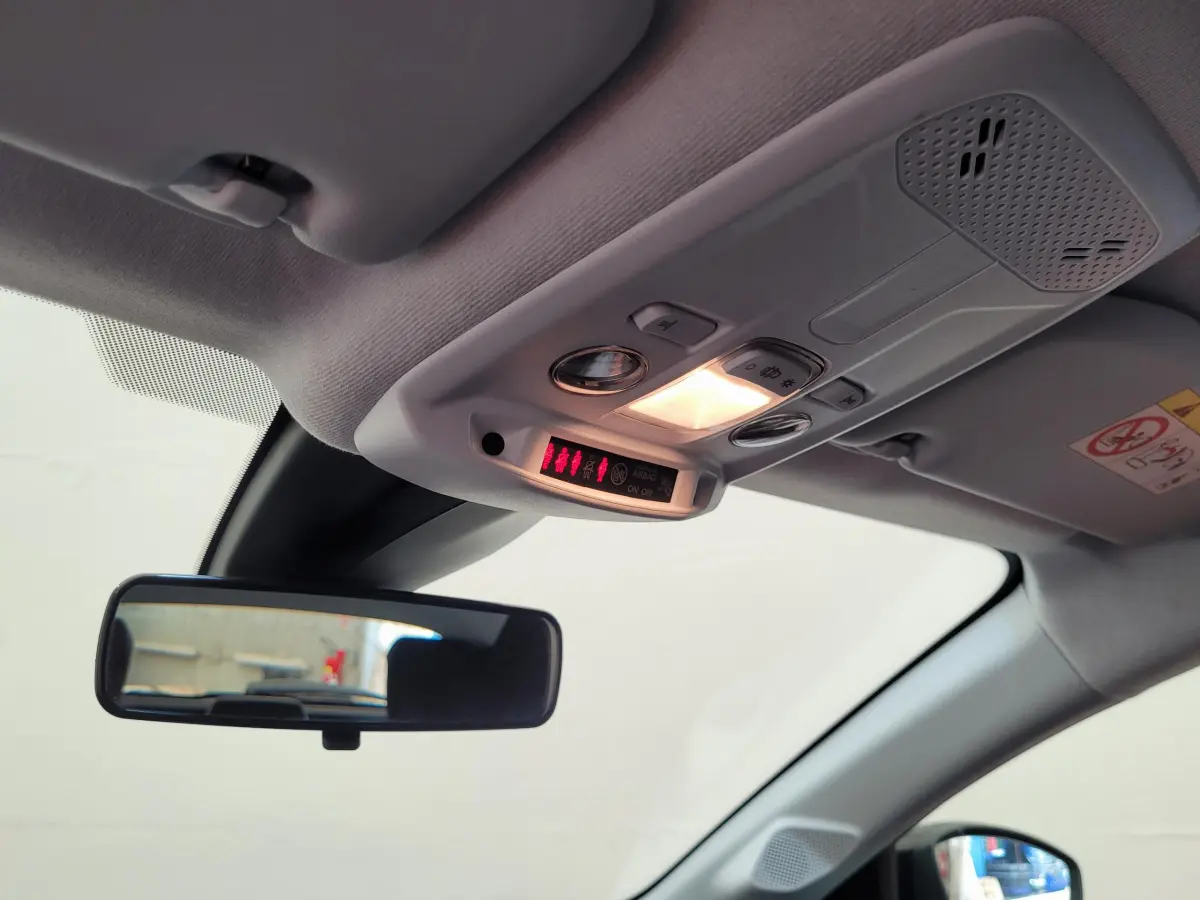 Vue intérieure du plafonnier et rétroviseur central d'une Peugeot 208 gris foncé, avec éclairage allumé.