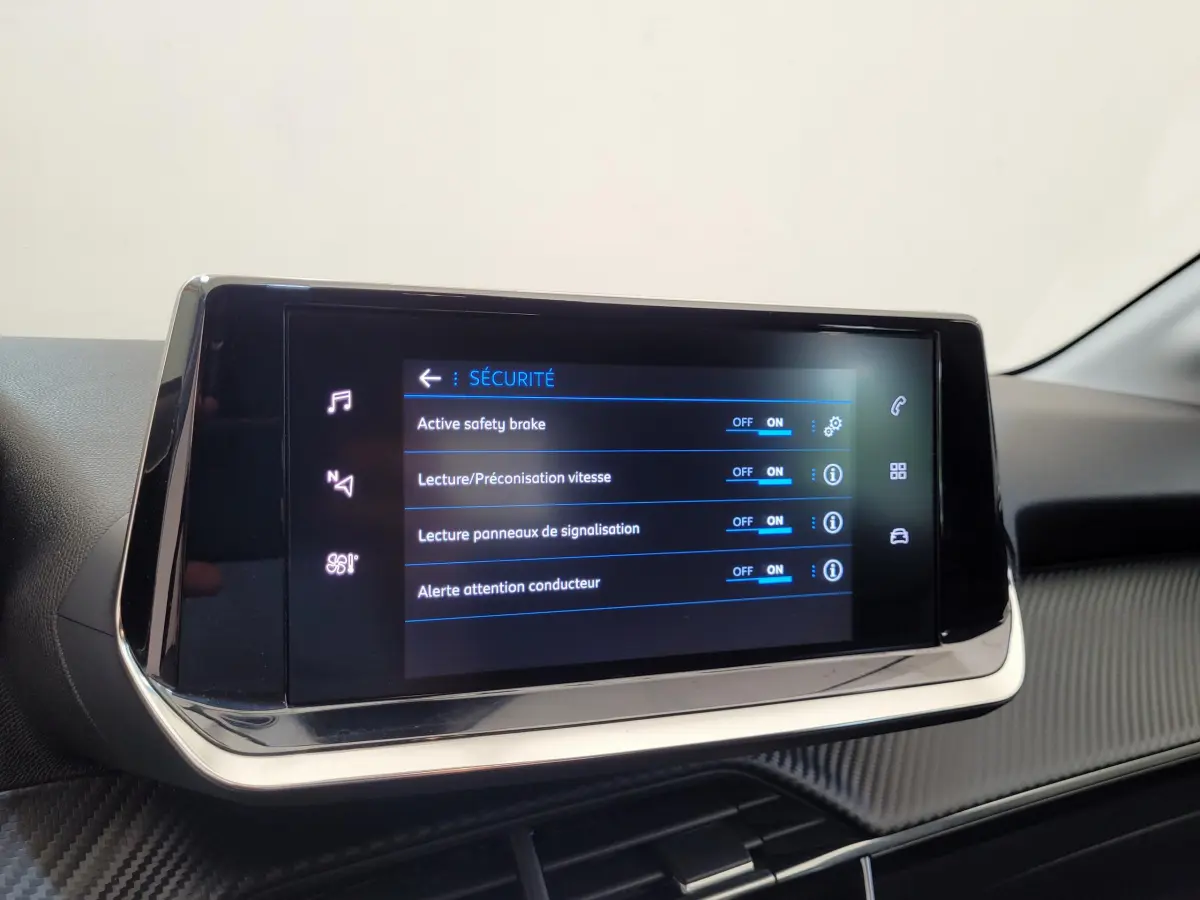 Écran tactile central affichant les réglages de sécurité dans l'habitacle d'une Peugeot 208 gris foncé.