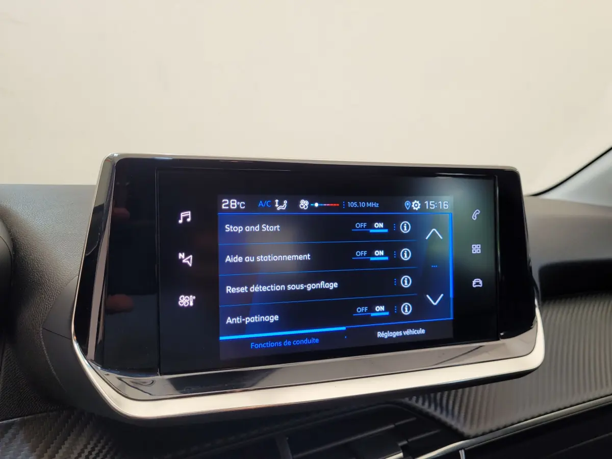 Écran tactile central de la Peugeot 208 gris foncé, affichant les réglages d'aide à la conduite en gros plan.