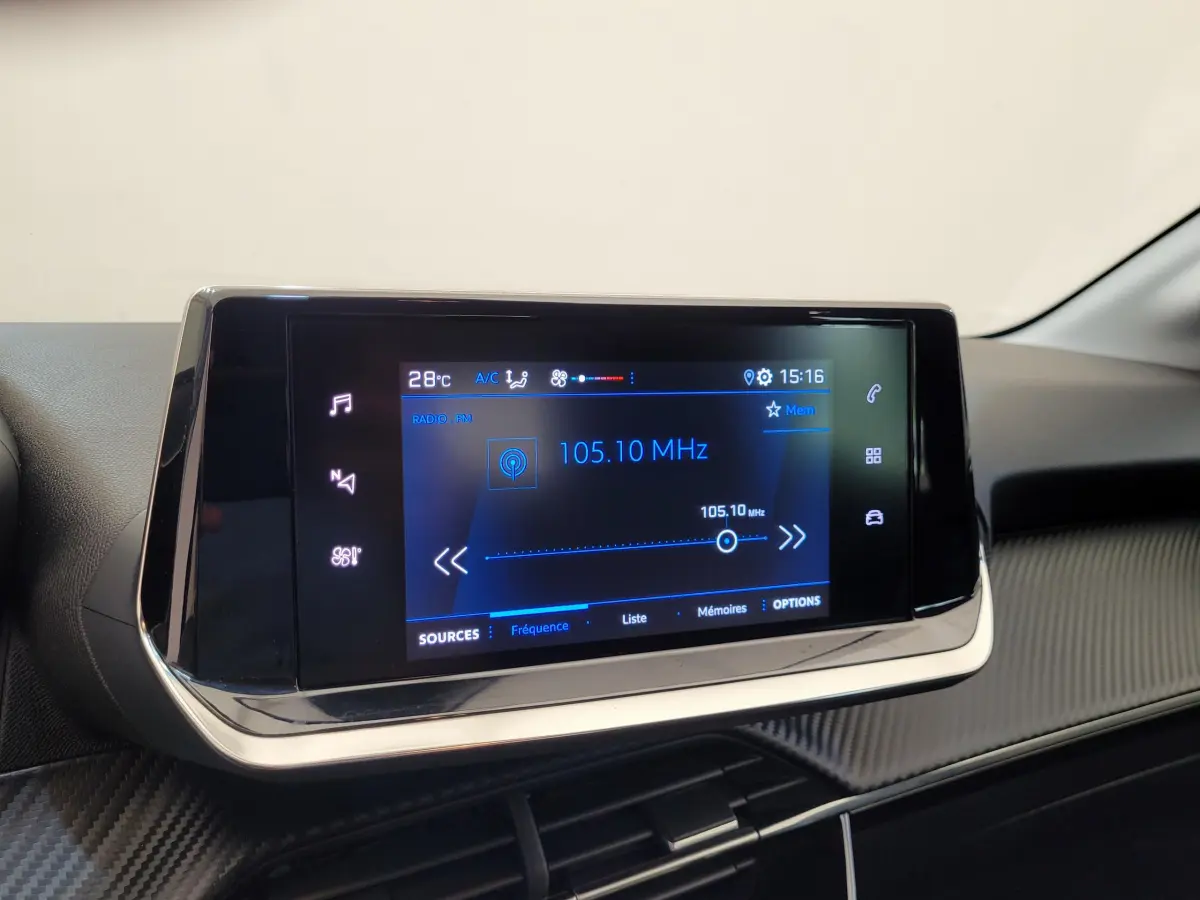 Écran tactile central 7 pouces de la Peugeot 208 gris foncé, affichant la radio FM à 105,10 MHz.