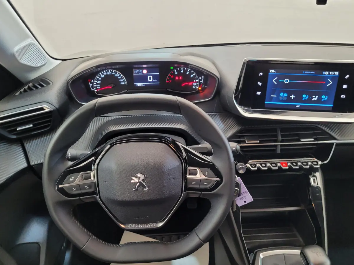 Vue intérieure centrée sur le volant cuir et tableau de bord numérique de la Peugeot 208 2023, finition Active Pack.
