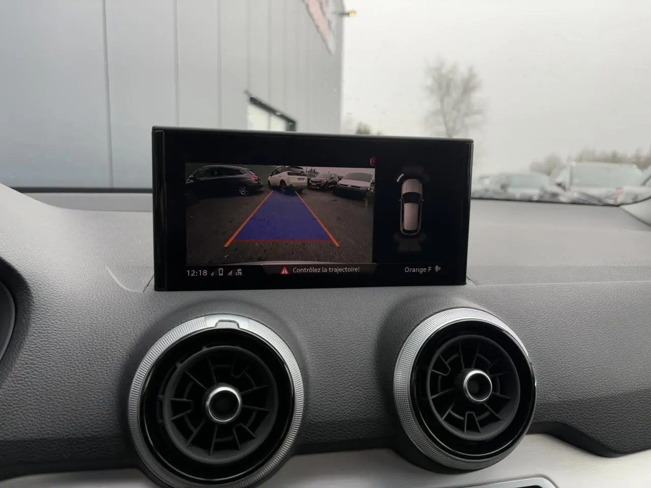 Vue intérieure du tableau de bord de l'Audi Q2 30 TFSI S-Line 2024, écran affichant la caméra de recul.